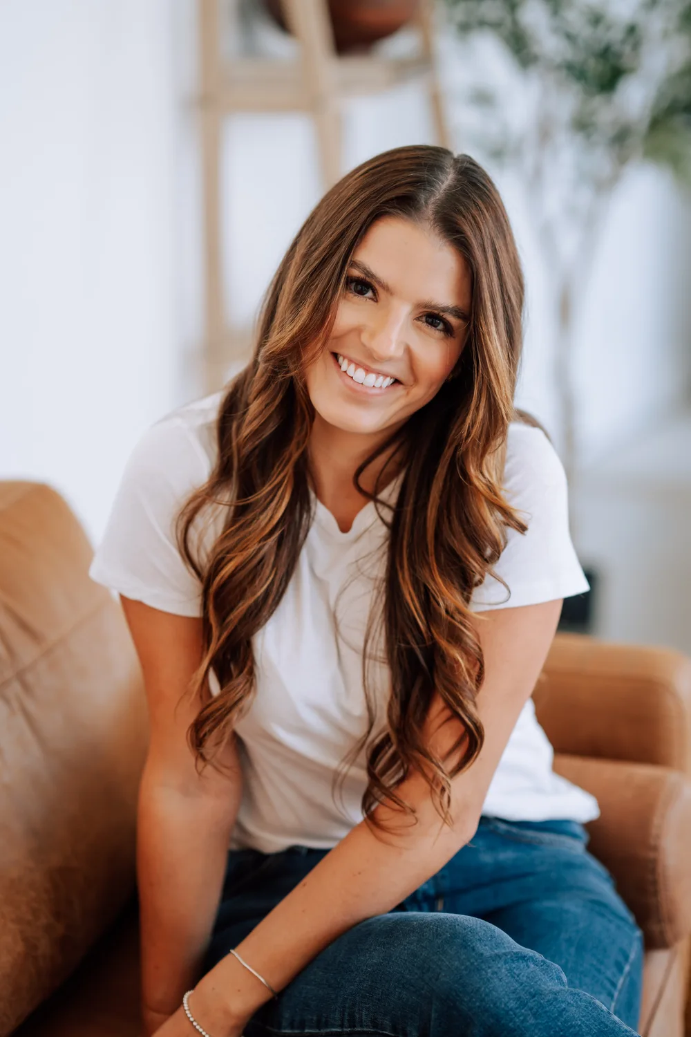 Alexandra Evans smiling while seated on a sofa